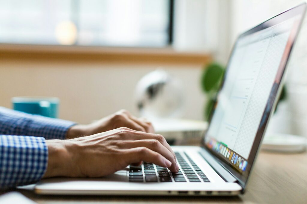 person typing on silver MacBook